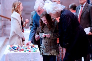 Sophia Knox (10) selects a hand-painted stone during the 70th Anniversary Service.  Each of the colourful stones was painted with one of the words ‘Give', ‘Act', ‘Pray', ‘Faith', ‘Hope' and ‘Love'. Photo credit: John Murphy/Aurora PA