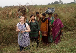 Christian Aid's Rosamond Bennett in a field with local ladies.