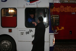 A bus driver calls Canon Neil Cutcliffe over to receive a donation to the Black Santa appeal.