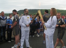 The Rev Andrew Ker passes the London 2012 Olympic Flame to Dianne McMillan.