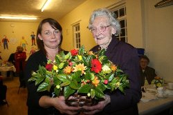Oldest serving member Maud Cochrane receives  flowers from Mrs Hayes.