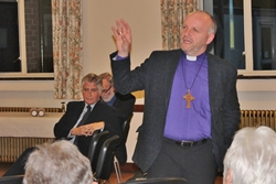 Roy Totten and Archdeacon Barry Dodds look on as Bishop Alan addresses the crowd.