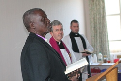 Bishop Hilary reads during the service at the CME meeting.