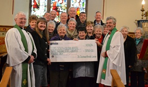 The rector of St Cedma's Parish Larne, Archdeacon Stephen Forde (right), with Rev Harold Sharp (left) and members of the Wednesday morning congregation, present Mrs Jenny Smyth (2nd from the left) of CMS Ireland with a cheque for £3,700.
