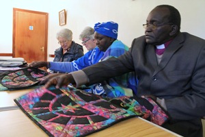 Bishop Stephen and Mama Rael admire the quilts they were shown by Mollie Hall.