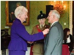 Vaughan Rosbotham receives his British Empire Medal from Dame Mary Peters.