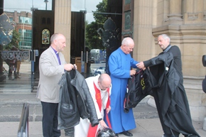 The Bishop of Connor and the Rev Campbell Dixon MBE, of St Anne's Cathedral, help the bikers prepare for the road.
