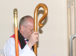 Bishop of Connor, the Rt Rev Alan Abernethy, prepares to knock on the doors of the new church at the start of the service of consecration and dedication.