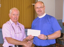 Rector of Whitehead and Islandmagee, the Rev Mark Taylor, presents a cheque to one of the charities to benefit from funds raised from the Lenten lunches.