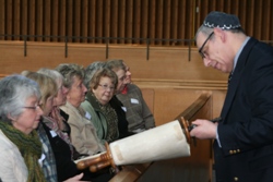 Neville shows the visitors the scrolls of the Torah.