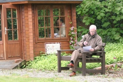 Ian Ingram takes a seat in the Quiet Garden to complete an exercise, while David Cromie and June Butler chose the summer house.