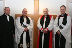 Clergy stand in front of the wooden cross, taken from the old St Columba's Building. From Left: The Rev William Taggart, Registrat; the Archdeacon of Connor, the Ven Dr Stephen McBride, Bishop's Commissary; Bishop Harold Miller and priest-in-charge of St Columba's, the Rev Dr Chris Easton.