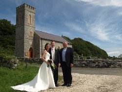 The Rev David Ferguson with newlyweds Siobhan and Rene outside St Thomas' Church, Rathlin Island.