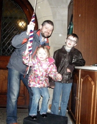 Young Nicholas and Victoria McCloskey and dad Andrew help Ring the Changes on Climate Change at St Bartholomew's on December 6.