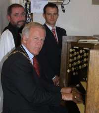 The Rector of St Colman’s, the Rev Tom Priestly and organist Alan Yarr look on as the Mayor of Lisburn, Councillor Trevor Lunn, re-takes the seat at St Colman’s church organ which he occasionally occupied when his father sang in the church choir.