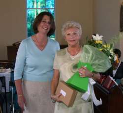 Lesley Highfield presents a bouquet of flowers to Ada Kirkwood (organist) in recognition of 50 years’ service to St Andrew’s.
