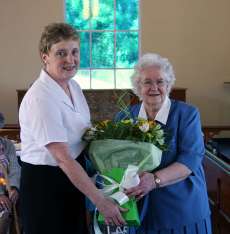 Mary McBride presents a bouquet of flowers to Vance Addis in recognition of 50 years service’ to St Andrew’s.  Vance was the first warden of the church.