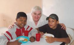 Eric Lewis from St Hilda’s, Kilmakee, with Colombian children who get meals at a project run by the church.