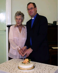 The rector of St Katharine's, Rev William Taggart, is helped to cut the anniversary cake by Mrs Jean McKnight, who celebrated her 100th birthday the following day.