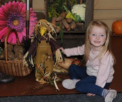 Summer Wright, granddaughter of the Rev Canon Sam Wright, admires the harvest display. Photo: John Kelly