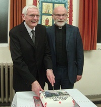 The Rev Bob Cotter cuts the anniversary cake with Hugh Rodgers, warden.