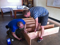 Christ Church parishioners Johnston Boyle and Raymond Geddis making a bookcase at the school in Luwero.