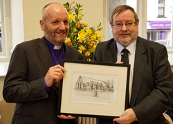 Project co-ordinator George Field presents Bishop Alan Abernethy with a specially commissioned picture of the Old Schoolhouse by artist Mark Strong.