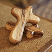 Hand carved olive wood crosses are give to patients.
