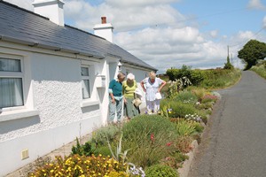 Helen Harper shows visitors some of the flowers in the roadside bed outside Forth Cottage.
