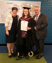Leah after her graduation with her mum and dad.