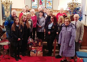 Mrs Pamela Turner, Mrs Anna Tyther along with pupils - Cailin McMullan, Jamie-Rae McAuley, Keona Dickson and Dara Hull presents  the Ven Stephen Forde, rector of St Cedma’s, with the hampers.  Also pictured are Rev Philip Benson, Rev Harold Sharp and parishioners from St Cedma's and All Saints.