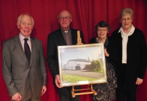 Mr Hilary Morrison (left) and Mrs Kaye Somerville (right), who  were parochial nominators when Canon George Irwin was appointed as rector of Ballymacash 27 years ago, present a framed picture of St Maark’s Church to Canon George Irwin while Mrs Irwin was presented with a flower arrangement. 