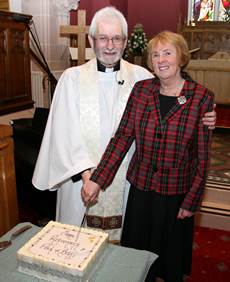 The Rev Paul Redfern and his wife Betty cut the cake presented to them to mark Paul's retirement from Kilbride Parish.