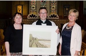 Karen Tilson, Rector’s Churchwarden (left), and Beth Harris, People’s Churchwarden, present a picture to the Rev Paul Dundas to mark the 25th anniversary of his ordination.