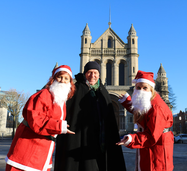 Belfast’s Black Santa Dean John Mann greets Downtown Radio and Cool FM’s Cash for Kids Santas Therese Maguire and Rachel Moore who were in Writer’s Square to launch the fifth annual Santa Dash which takes place in the square on December 4. Dean Mann begins the 40th Black Santa Sit-out on the steps of St Anne’s on December 16.