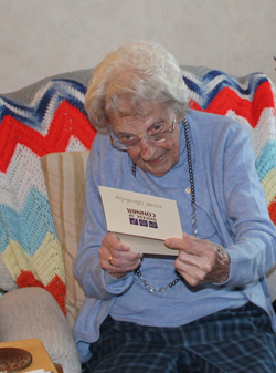 Smiles as Bertha reads her birthday card from the Bishop of Connor.
