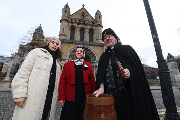 Dean Stephen Forde pictured outside St Anne's Cathedral with Nemat and Melika, refugees from Syria and Algeria who are supported by Footprints Women's Centre.